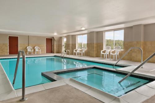 a swimming pool in a hotel room with chairs at Country Inn & Suites by Radisson, Wytheville, VA in Wytheville