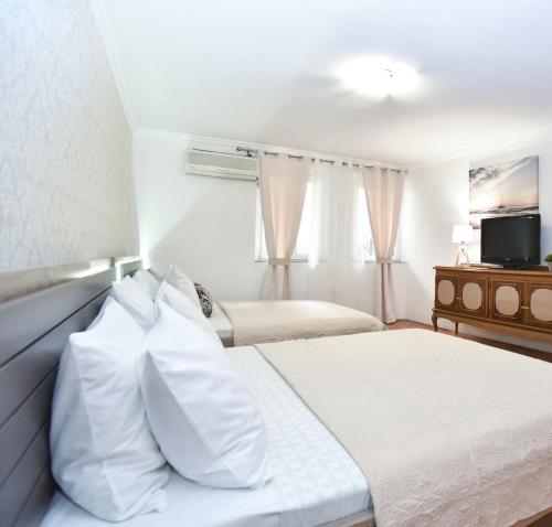 a hotel room with two beds and a television at Palm square 1 Old town apt in Budva