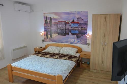 a bedroom with a bed and a painting on the wall at Sobe Mira in Trebinje