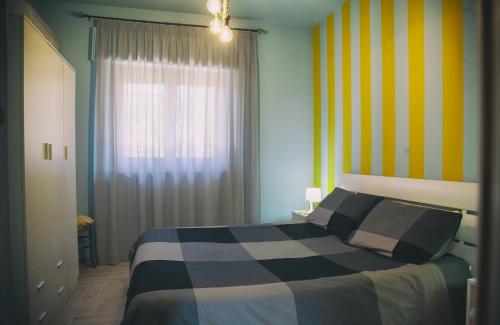 a bedroom with a bed with a striped wall at Villalba in Balestrate