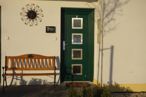 a green door with a bench in front of it at Lednicko-valtický apartmán in Hlohovec