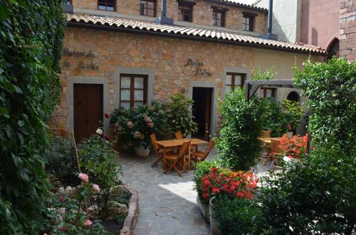 um jardim com mesa, cadeiras e flores em CAN LLORENÇ em Prades