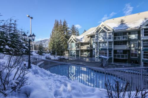 a house with a swimming pool in the snow at The Woodrun Lodge by Whiski Jack in Whistler