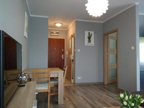 comedor y sala de estar con mesa y sillas en Apartament Edelmana, en Gorzów Wielkopolski