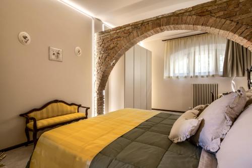 Un dormitorio con una cama y una pared de ladrillo. en Villa Bonelli, en Siena