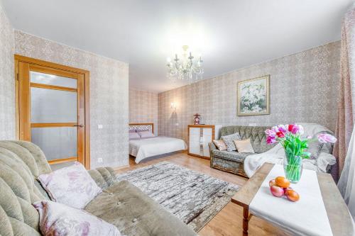 Helen Apartments Galleria Minsk في مينسك: غرفة معيشة مع أريكة وطاولة