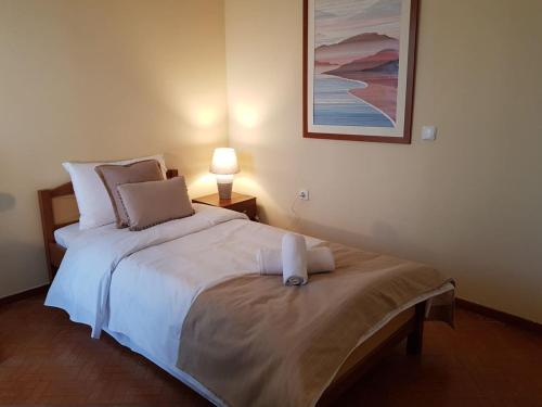 a bedroom with a white bed with a lamp on it at ANNA'S SWEET HOME in Nea Makri