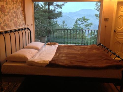 a bed in a room with a large window at Bhurban Hill Apartments in Bhurban