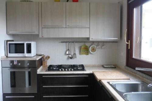 una cucina con piano cottura e forno a microonde di Ampia e graziosa Casa Vacanza a Pula