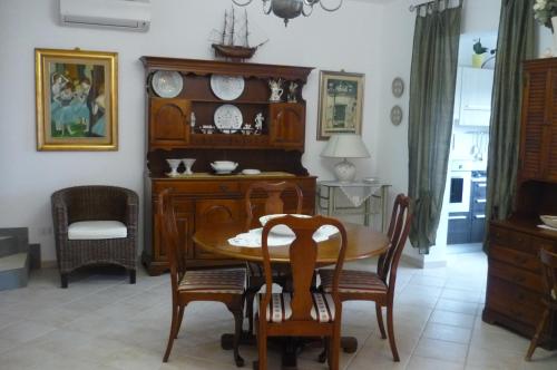 una sala da pranzo con tavolo e sedie in legno di Ampia e graziosa Casa Vacanza a Pula