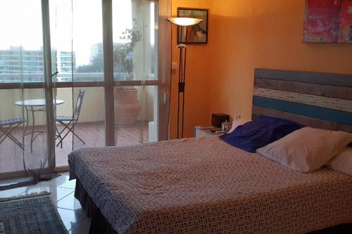 une chambre avec un lit et un balcon avec une table dans l'établissement dupleix U Forcone, à Ajaccio