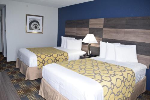 a hotel room with two beds and a lamp at Baymont by Wyndham - Chicago - Addison - O'Hare in Addison