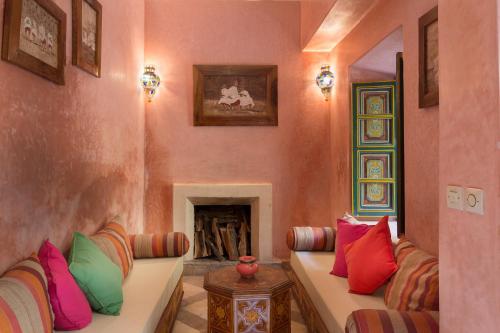a living room with a couch with colorful pillows at Riad Julia in Marrakesh