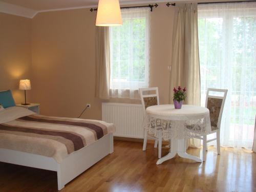 a bedroom with a bed and a table and chairs at Dworek Pod Różą in Karwieńskie Błoto Pierwsze