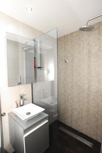 a bathroom with a white sink and a shower at Thalia Premium Apartment in Kavála