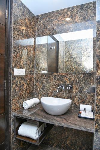 a bathroom with a sink and a mirror at Hotel Suncity Plaza, Sitapura, Jaipur in Jaipur