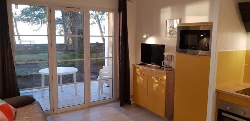 - un salon avec une télévision au-dessus d'une commode dans l'établissement Ti Korelo Cap Coz, à Fouesnant