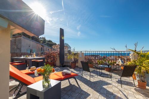 uma varanda com mesas e cadeiras e vista para o oceano em Le Château - THE MOST BEAUTIFUL SIGHT IN OLD TOWN, private terrace em Nice