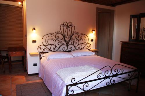 a bedroom with a bed with a wrought iron headboard at La casa di Chiara in Diano dʼAlba