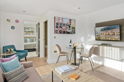 ein Wohnzimmer mit einem Sofa und einem Tisch in der Unterkunft The Chronicle by Supercity Aparthotels in London