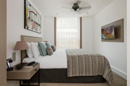 una camera con letto, comodino e letto sidx sidx sidx. di The Chronicle by Supercity Aparthotels a Londra