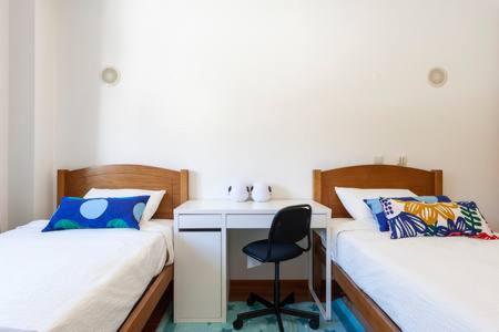 a room with two beds with a desk and a chair at luxury lisbon apartment T2 in Lisbon