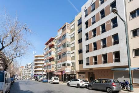 a city street with cars parked in front of buildings at luxury lisbon apartment T2 in Lisbon