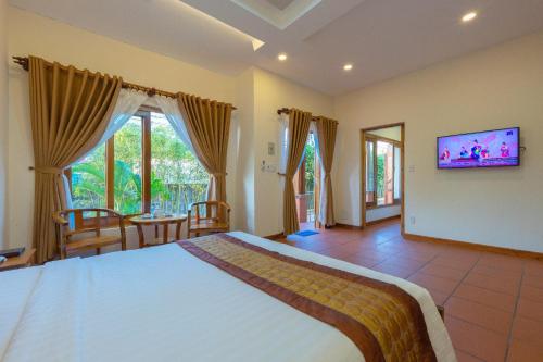 1 dormitorio con 1 cama grande y TV en la pared en Phu Quoc Bungalow Yen Thanh, en Phu Quoc