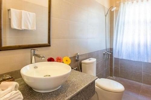 une salle de bain avec un lavabo blanc et des toilettes dans l'établissement Phu Quoc Bungalow Yen Thanh, à Duong Dong