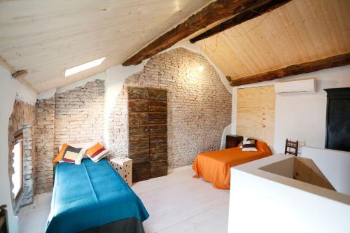 ein Schlafzimmer mit einem Bett in einem Zimmer mit Ziegelwand in der Unterkunft Wehomes- Cozy House - RhoFieraMilano - Parking - self Check-in - Galeazzi - Mind in Rho