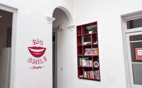 a book shelf with a big smile dental sign at Student’s Hostel in Montevideo