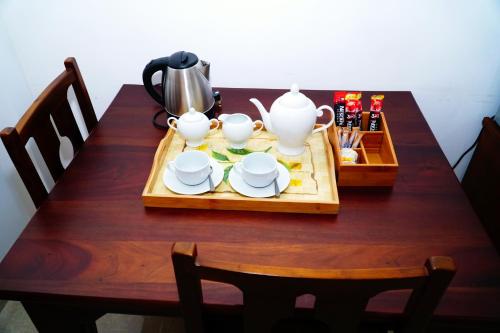 a wooden table with a tea set on it at Airport 4 Season Transit Hotel in Katunayake
