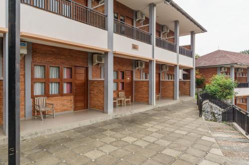 a row of brick buildings with chairs and tables at RedDoorz Plus at Hotel Negeri Baru Lodaya Puncak in Bogor