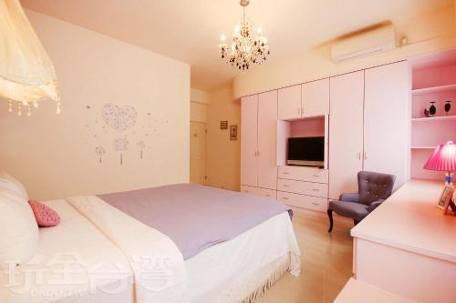 um quarto com uma cama, uma cadeira e uma televisão em Full House em Magong