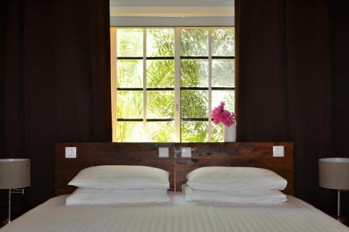ein Schlafzimmer mit einem Bett und einem Fenster darüber in der Unterkunft Jan Kok Lodges in Willibrordus