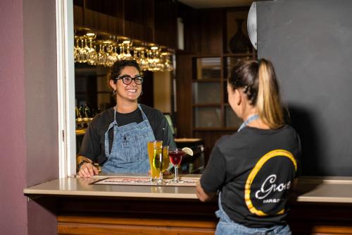 a woman standing at a counter in a bar at Wattle Grove Motel in Perth