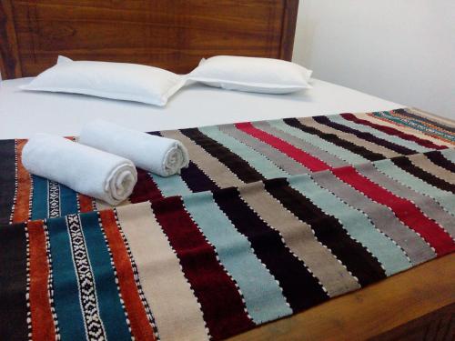 a bed with two rolled up towels on it at DAM HOUSE (Near Adams Peak) in Maskeliya