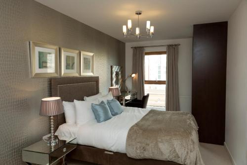a bedroom with a large bed with blue pillows at Exclusive Tower Bridge Apartment in London