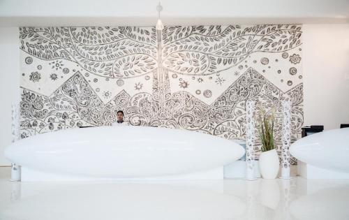 a bathroom with a white tub and a patterned wall at Mangrove Tree Resort World Sanya Bay-Coconut in Sanya