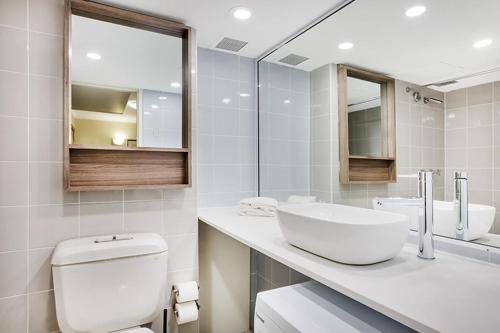een badkamer met een wit toilet en een wastafel bij Park View Apartment in Sydney