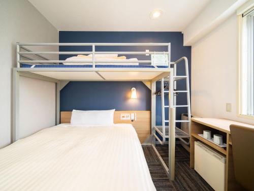 a small room with bunk beds and a desk at Super Hotel Towada Natural Hot Springs in Towada