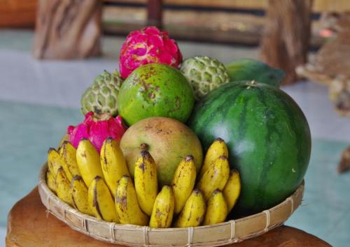 a basket of bananas and other fruits on a table at Budi Sun Resort, Flores, Maumere in Maumere