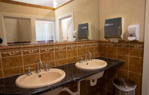 a bathroom with two sinks and a mirror at Criterion Hotel Gundagai in Gundagai