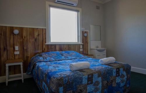 a bedroom with a bed with two pillows on it at Criterion Hotel Gundagai in Gundagai