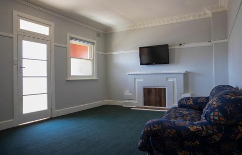 a living room filled with furniture and a fire place at Criterion Hotel Gundagai in Gundagai