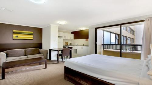 a bedroom with a bed and a living room at In the City Studio at College St in Sydney