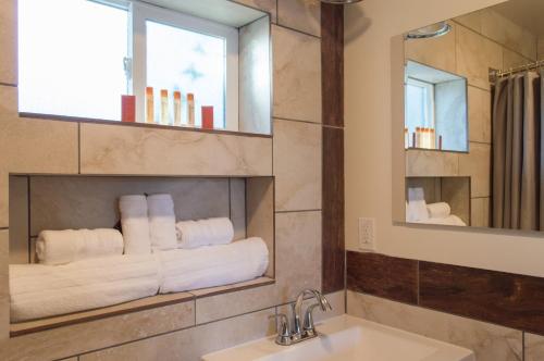 a bathroom with a sink and a mirror and towels at Casa Del Sol in Carpinteria