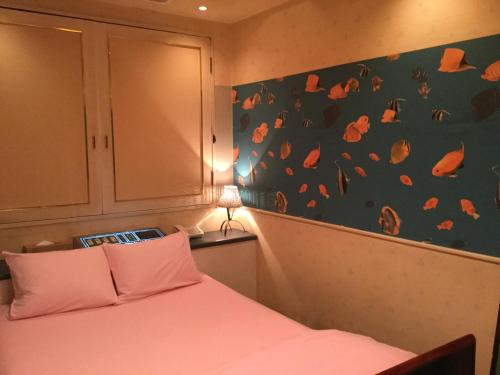 a bedroom with a bed and a wall with orange leaves at Dear Place(Adult Only) in Osaka