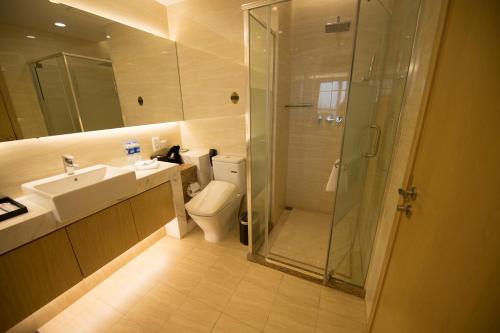 a bathroom with a shower and a toilet and a sink at Suzhou Sun Plaza Hotel in Suzhou