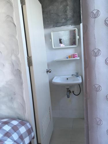 Baño pequeño con lavabo y espejo en You In House URT Surathani Airport, en Suratthani